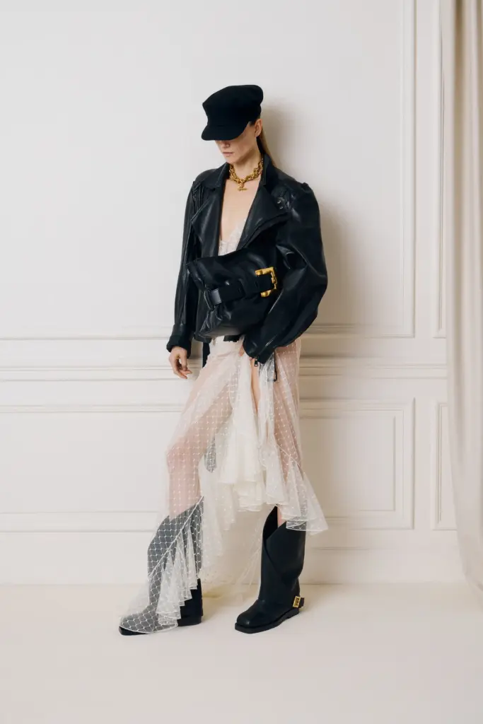 Najupečatljivije Pre-Fall 2025. kolekcije
Olivier Rousteing nastavlja da gradi raskošnu viziju Balmain kuće.
Krojevi koji kombinuju dramatične siluete—poput mini-pannier jakni i kaputa s naglašenim ramenima—donose mešavinu istorijskog i futurističkog.
dinamicna kombinacija sa crnim kaubojkama, cipkanom maxi suknjom i koznom jaknom crne boje